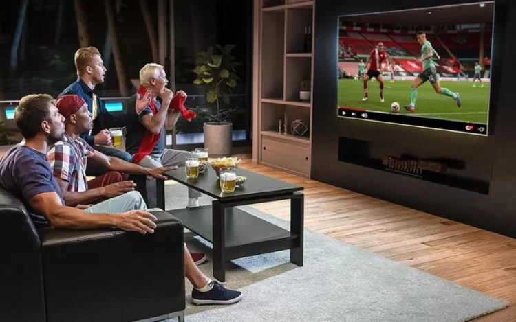 High-quality streaming TV service banner showing people watching live sports, international channels, and entertainment on a smart TV in a modern living room.